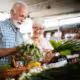 An elderly couple checking out produce at a San Diego farmers market