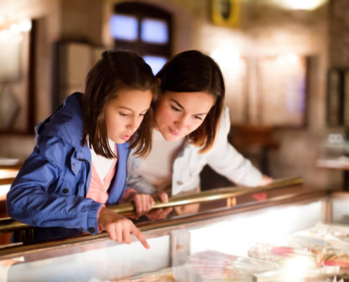 A mom and daughter look at an artifact in one of the best museums in San Diego