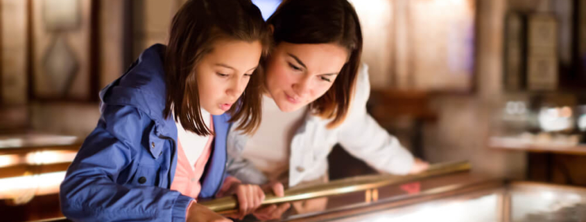 A mom and daughter look at an artifact in one of the best museums in San Diego