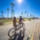 Girls riding a tandem bike on the Mission Beach Boardwalk in San Diego