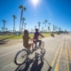 Girls riding a tandem bike on the Mission Beach Boardwalk in San Diego
