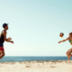 A man and woman playing beach volleyball on a beach in San Diego