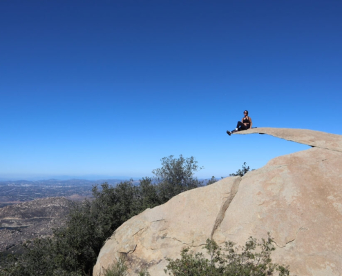 A man sitting on Potato Chip Rock, one of the best Instagram spots in San Diego