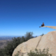 A man sitting on Potato Chip Rock, one of the best Instagram spots in San Diego